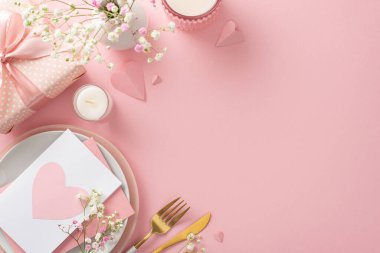 Anneler Günü brunch 'ı konsepti. En üstteki düz tabaklar, çatal bıçak takımı, laleler, hediye kutusu, vazo, posta kartı, tanıtım içeriği veya metin için yeri olan pastel pembe arka planda dekoratif kalpler.