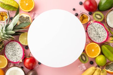 Tabakta bir cennet. Ejderha meyvesi, kivi, papaya, avokado, tomarillo, ananas, portakal, limon ve hindistan cevizi gibi pembe arka planda palmiye yaprakları ve boş bir daire şeklinde meyvelerin üst görüntüsü.