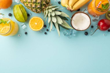 Kaçış konseptini tazeliyorum. Cam kavanozda taze meyve suyu veya kokteyl manzarası kivi, papaya, ananas, granadilla, mavi arka planda muz markalaştırmak için boş bir alan.