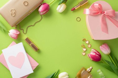 Klas Anneler Günü konsepti. Üst görünüm düz el çantası, hediye kutusu, laleler, ruj, makyaj fırçası, pastel yeşil arka plan üzerinde kartpostal ve küpeler