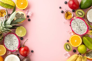 Yaz meyvesi tabağı. Ağız sulandıran bir daire, pembe arka planda ejderha meyvesi, kivi, papaya, ananas, portakal, tomarillo, çarkıfelek meyvesi, muz ve hindistan cevizi gibi egzotik meyvelerin üst görünümü yatıyordu.