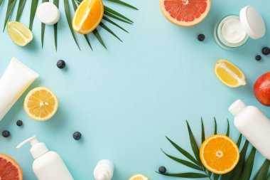 Zarif yaz teni konsepti. Üst kattaki düzlük krema şişeleri, kavanozlar, serum, sulu narenciye dilimleri, çiçekler ve yapraklı pipetler.