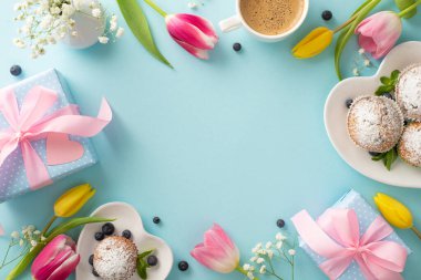 Minnettarlığını annene göster. Top view düz kapkek yatağı, hediyeler, kahve ve pastel mavi arka planda laleler. Boş alan bir selamlama ya da reklam için mükemmel.