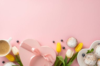 Anneler Günü 'nü modayla kutlayın. Lezzetli çörekler, hediyeler, kahve fincanları ve pastel pembe arka plandaki lalelerle dolu bir daireyle. Mesajınız ya da mesajınız için boş bir alan olsun.