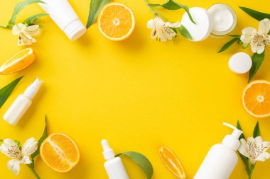 Yaz meyvesi güzellik konsepti. Üst görünüm düz cilt ürünleri ile turuncu dilimler çiçek parlak sarı arkaplan üzerinde metin veya reklam için boş alan