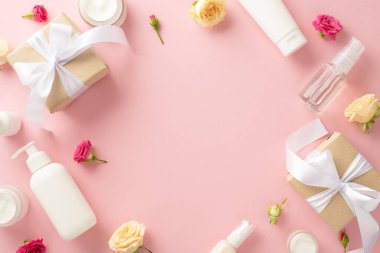 Lüks doğal cilt bakımı konsepti. Üst manzara düz, zarif pompa şişesi, narin pipet, hediyeler, krema kavanozları ve gül yapraklı tüpler pastel pembe arka plan, boş alan.