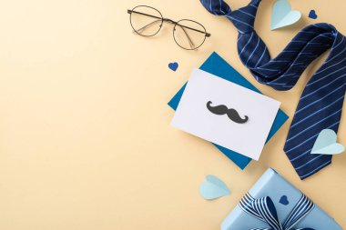 Moda Babalar Günü planı. Zarfın yukarıdan görünüşü, kurdeleli hediye kutusu, kravat, bıyık, aksesuarlar, gözlük, bej arkaplan üzerinde kalpler kopya için yer var.