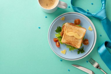 Babanıza bir kahvaltı sürprizi ile mutlu babalar günü dileyin. Bıyık şekilli peynirli, çatal bıçaklı, kahveli, kravatlı ev yapımı tostun en üst görüntüsü.