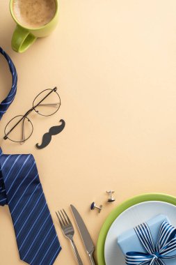 Etkileyici bir Babalar Günü sofra kurma fikri yarat. Çatal bıçak takımı, sofra takımı, kahve takımı, gözlük, bıyık, kravat, fiyonklu hediye kutusu, bej bir arka plan ve metin için boş bir alan