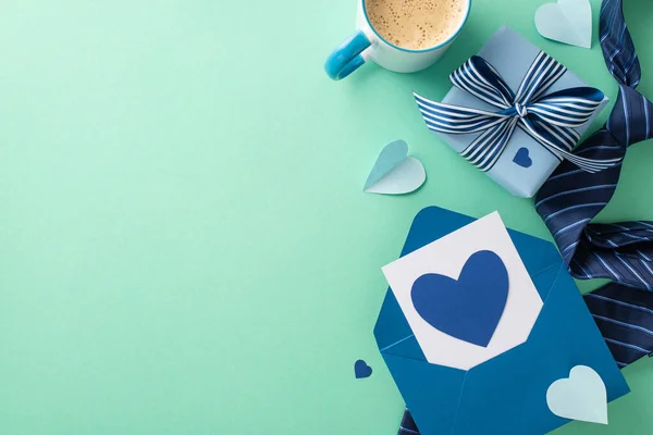 stock image Trendsetting Father's Day design. Overhead shot of envelope with postcard, present box, coffee cup, and accessories on a turquoise backdrop with an empty space for text