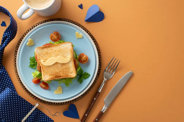 stock image Celebrate Father's Day with a homemade breakfast surprise: Top view of sandwich with veggies and mustache-shaped cheese, cutlery, coffee, necktie on brown background with empty space for text
