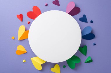 LGBTQ + topluluğuna olan desteğinizi, gökkuşağı renkli kalplerle çevrili boş bir çemberin yer aldığı leylak yüzeyindeki sembolik kompozisyonun bu üst kare düz tablosu ile gösterin