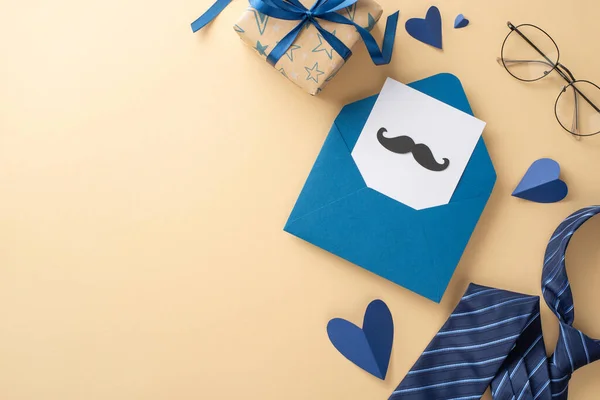 stock image Father's Day is the perfect time to showcase a top view of hearts, glasses, blue necktie, open envelope, postcard with mustaches, and a gift box on a beige background featuring an empty space for text