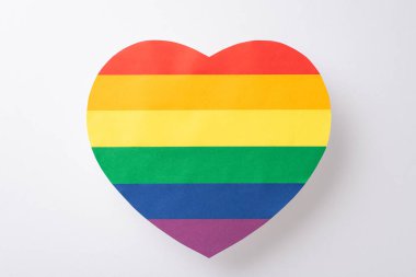 Büyük gökkuşağı renkli kalp şeklinde kartpostal gibi LGBT desteği için sembolün yukarıdan aşağı perspektifi, metin veya reklamlar için boş bir arkaplan üzerine yerleştirilmiş beyaz bir arkaplan