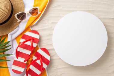 Güneş öpücüğü esasları. Yaz aksesuarları: güneş gözlüğü, güneş şapkası, kırmızı parmak arası terlik, sarı havlu ve palmiye yaprakları. Metin veya reklamlar için boş bir daire ile kumsal sahili arkaplanı