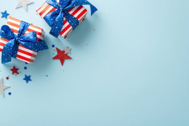 Yukarıdan alınan sembolik parti süslemeleri: üst görünüm parıldayan yıldızlar, parıldayan konfeti ve hediye kutuları, hepsi mesaj veya reklam için boş bir alan içeren mavi bir arkaplan üzerinde