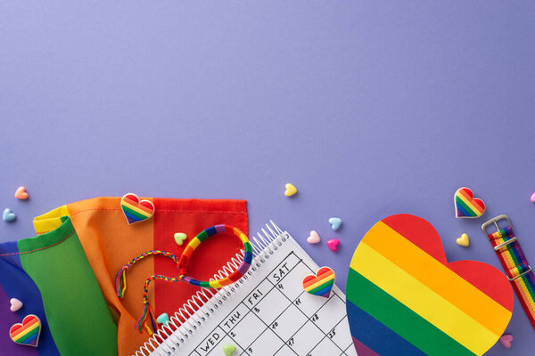 LGBT-themed top view flat lay on lilac background with rainbow flag, pin badges, wristlet, hearts, and calendar with meeting date