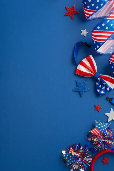 Sembolik parti aksesuarları dikey tepeden çekildi. Kıvırcık kurdele, parıldayan yıldızlar, parti saç bandı, Amerikan bayrağı renginde papyon mavi bir fon üzerinde mesaj veya reklam için boş bir alan