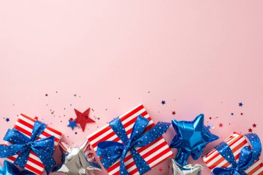 Anma Günü ABD teması. Vatansever parti dekorasyonlarının, balonların, parlayan yıldızların, şenlikli konfetilerin ve hediye kutularının en üst görüntüsü, metin veya reklam için alanı olan pastel mavi arka planda.