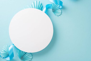 Üstten bakıldığında, beyaz boş çemberin, pastel mavi kurdeleli ve origami kağıtlı kalplerinin fotokopi alanı ile izole edilmiş ışık arkaplanındaki en üst görüntüsü.
