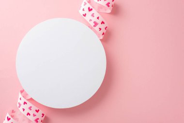 Beyaz boş dairenin en üstteki fotoğrafı pembe kurdeleyle çevrili basılmış kalplerle izole edilmiş pembe arkaplanlı fotokopi alanı ile.