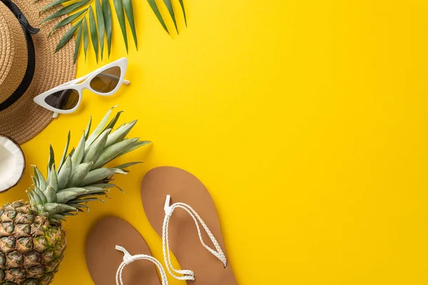 stock image Immerse yourself in the summer relaxation with this top view flat lay. With a sunhat, palm leaves, flip-flops, coco nut and a pineapple on a bright yellow background, the empty space for text