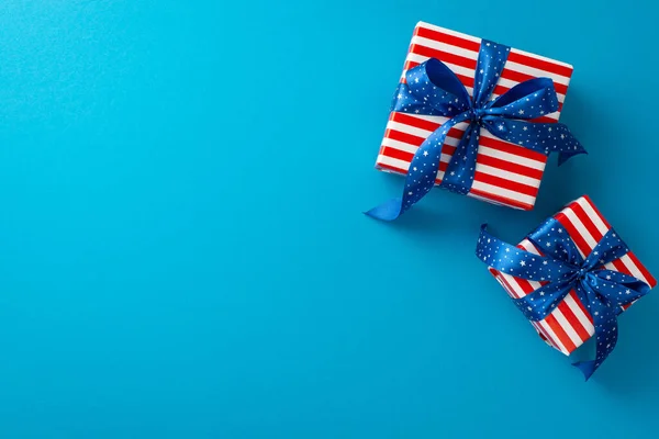 stock image Delight in the top view, revealing a stunning arrangement of two gift boxes adorned with the USA flag pattern. Against a blue background, awaiting your text or adverts