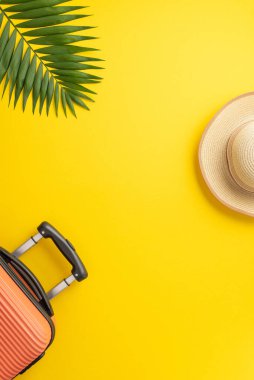 Yaz tatilinin hayalini kuruyorum. Bavulun dikey üst görüntüsü, plaj aksesuarları, güneş şapkası ve parlak sarı arka planda palmiye yaprağı. Metin veya reklam için kullanılabilir alan