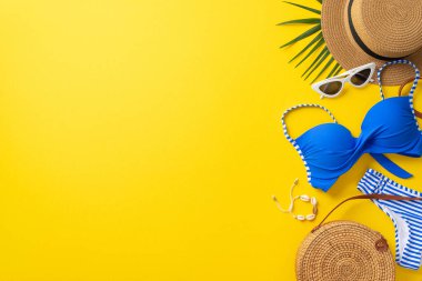 Rüya gezisi konsepti. Hasır şapka ve küçük çanta, mavi mayo, güneş gözlüğü ve kabuk bileziği.