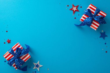 Karşınızda ABD 'nin Bağımsızlık Günü kutlamalarının büyüleyici görüntüsü. Göz kamaştırıcı yıldızlar, konfetiler, ABD bayrak desenli hediyeler. Mavi arka plana karşı dizilmiş, metin veya reklam için ideal.