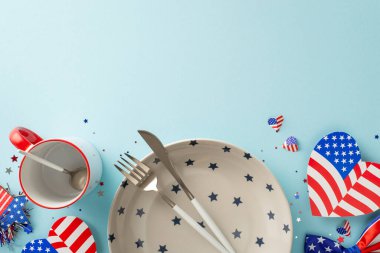 Amerika 'nın Bağımsızlık Günü için yaratıcı masa sunumuna hazırlanın. Üst görünüm sembolik öğeler, tabak, çatal bıçak, fincan, Amerikan bayrak desenli kalpler, konfeti, pastel mavi arka plan, metin veya reklam için alan