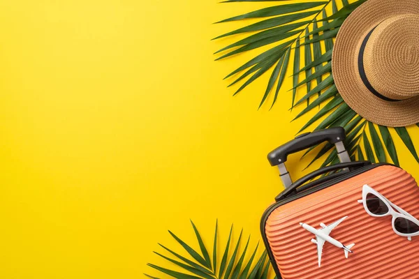 stock image Tropical journey concept. Top view photo of orange suitcase with airplane model and sunglasses on it surrounded by palm leaf and straw hat on isolated bright yellow background with copy-space