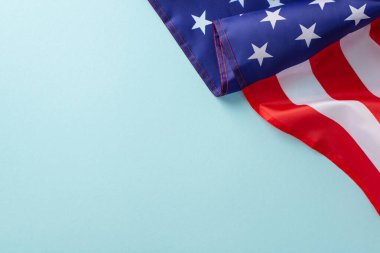 Amerikan federal bayramı konsepti. Amerika Birleşik Devletleri bayrağının açık mavi izole arkaplanda fotokopi uzayıyla yüksek açılı fotoğrafı