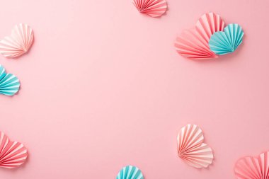 Boş beyaz çemberin üst görüntüsü. Renkli pembe ve mavi kağıt origami kalplerle izole edilmiş açık pembe arkaplanlı.