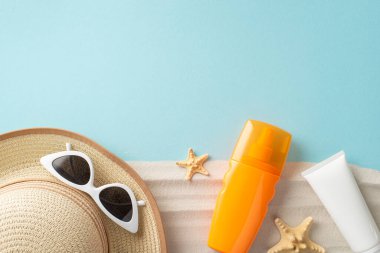 Etiketsiz SPF krem şişelerinin üst görüntüsü, güneş gözlüğü, güneş şapkası, yıldız balıkları, markalaşma veya promosyon için boş bir alan ile pastel mavi ve kumlu bir zemin üzerine kuruludur.