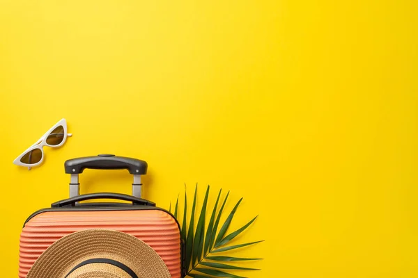stock image Dream vacation concept. High angle view photo of orange suitcase with palm leaf underneath and straw hat on it near white sunglasses on isolated bright yellow background with copy-space