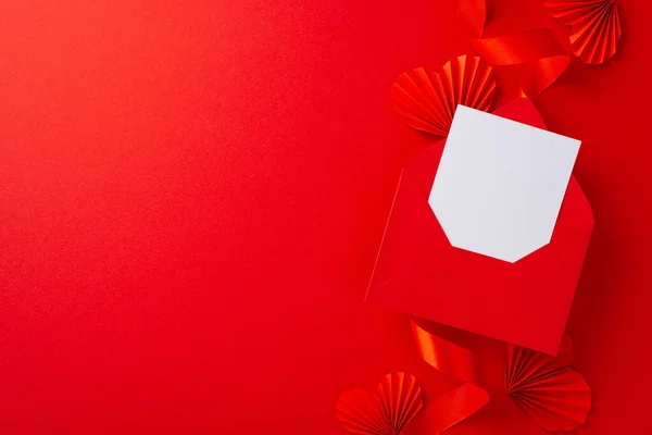 Фото Белого Пустого Конверта Окруженного Ярко Красной Лентой Бумажными Сердцами — стоковое фото