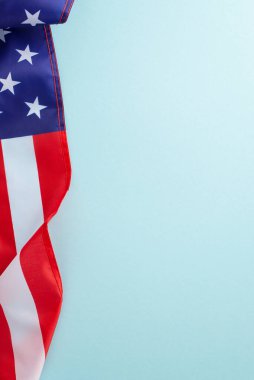 Amerikan federal bayramı konsepti. Amerika Birleşik Devletleri bayrağının yüksek açılı dikey görüntüsü açık mavi izole arkaplan üzerinde fotokopi alanı ile