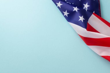Amerika 'da resmi tatil kavramı. Amerika Birleşik Devletleri bayrağının açık mavi izole arkaplanda fotokopi uzayıyla yüksek açılı fotoğrafı
