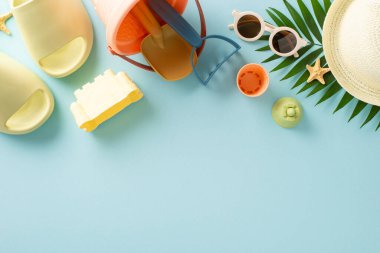 Çocuklu tropik bir tatil köyü. Palmiye yaprağı, kum oyuncakları, panamalı terlikler ve Celeste 'de izole edilmiş arka planda güneş gözlüğü olan boş bir yerin en üstteki fotoğrafı.