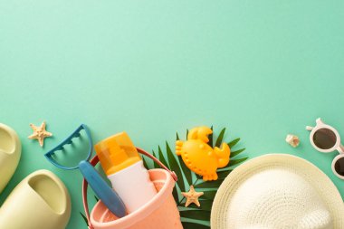 Çocuklarla mükemmel plaj rahatlığına dalın: Çocukların kum oyuncaklarını, terliklerini, güneş şapkalarını, güneş gözlüklerini, deniz yıldızlarını reklam ve metin için kopyalama alanı ile tepe arkaplamalı tepe arkaplamalı fotoğraflara dalın