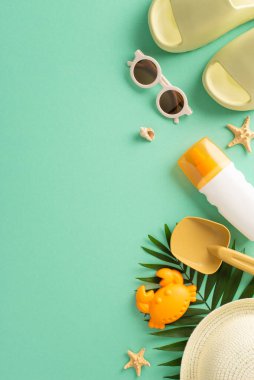 Sahilde çocuklarla plaj rahatlığı. Çocuklar için kum oyuncakları, panama, terlik, güneş gözlüğü, palmiye yaprağı ve kopyalanmış deniz yıldızı fotoğrafı