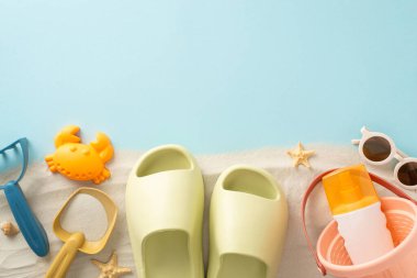 Çocuklarla deniz kenarında keyifli bir yaz kaçamağı: Çocuklar için kum oyuncakları, terlikler, güneş gözlükleri ve deniz yıldızının izole edilmiş mavi arka planda çekilmiş resmi