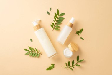 Çevre dostu kozmetik konsepti. İzole edilmiş bej arkaplan üzerinde geri dönüşümlü kozmetik kaplar, okaliptüs ve eğreltiotu yapraklarının üst görünümü