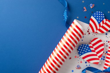 Amerika 'da Bağımsızlık Günü hazırlıkları. Üst görünüm, temalı ambalaj kağıdı rulosu ile olayın özünü yakalar, bayrak desenli kalp şeklindeki tasarımlar, mavi arkaplan, metin için yer sağlar