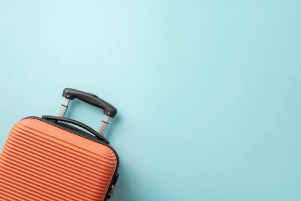 stock image Dreamy summer trip. Orange suitcase seen from top view on a pastel blue background, offering space for text or advertising