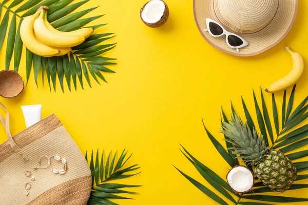 stock image Sun-soaked dreams ahead. Top view of beach bag, accessories, eyewear, cap, spf cream, shell bijouterie, palm leaves, succulent tropical fruits on vivid yellow background with empty frame for text