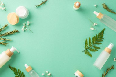 Bitkisel doğal kozmetik konsepti. Geri dönüşümlü kozmetik konteynırların üst görünüm fotoğrafı ve parantez ve okaliptüs yaprakları ile izole edilmiş turkuaz arkaplan ve kopyalanmış turkuaz arkaplan