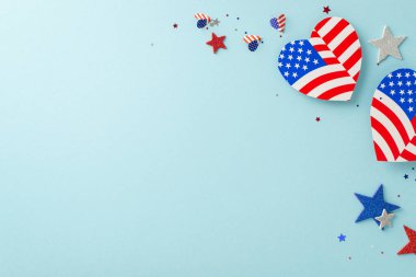 Ulusal bayram kutlaması. Sembolik dekorasyonların yukarıdan aşağıya bakışı: Amerikan bayrağı tasarımı, parıltılı yıldızlar, konfetileri gösteren kalpler, mesajlar veya reklamlar için boş bir alanı olan pastel mavi bir tabana karşı