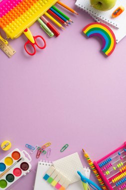 Okul malzemesi. Renkli koleksiyonun dikey üst görünümü: egzersiz kitapları, kalem kutusu, resim resimleri, yapışkan notlar, plasticin ve kişiselleştirilmiş metin için alanı olan pastel leylak yüzey üzerinde daha fazlası